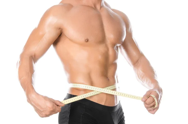 Bodybuilding and Sports theme: handsome strong bodybuilder holding centimeter tape to measure body isolated on white background in studio — 스톡 사진