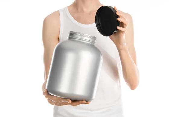 Bodybuilding and Sports theme: a thin man in a white T-shirt and jeans holding a plastic jar with a protein isolated on a white background in studio — ストック写真