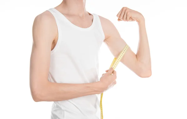 Bodybuilding and Sports theme: a thin man in a white T-shirt and jeans with measuring tape isolated on a white background in studio