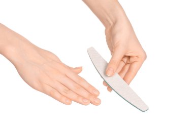 Health and hand care topic: a woman's hand holding a nail file for manicure isolated on white background in studio