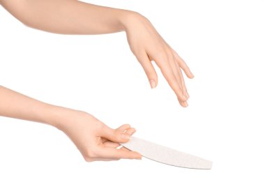 Health and hand care topic: a woman's hand holding a nail file for manicure isolated on white background in studio