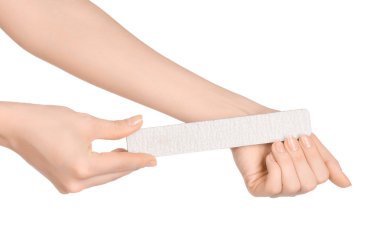 Health and hand care topic: a woman's hand holding a nail file for manicure isolated on white background in studio