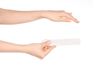 Health and hand care topic: a woman's hand holding a nail file for manicure isolated on white background in studio