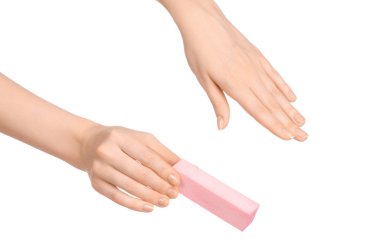 Health and hand care topic: a woman's hand holding a nail file for manicure isolated on white background in studio