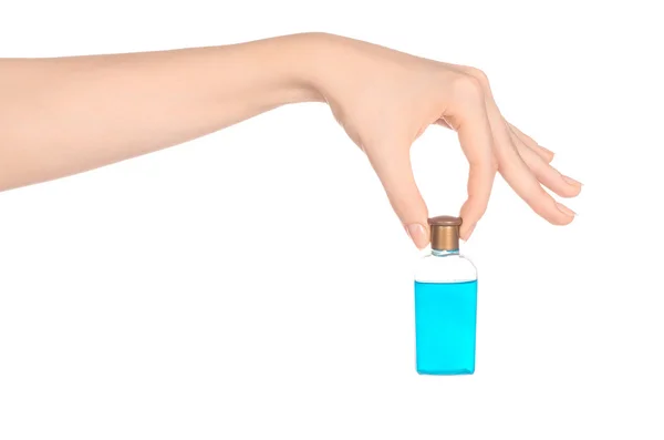 Thema Schönheit und Gesundheit: die Hand einer Frau, die eine kleine blaue Flasche Shampoo im Studio hält, isoliert auf weißem Hintergrund — Stockfoto