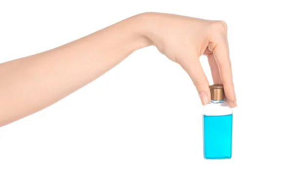 Beauty and health topic: a woman's hand holding a small blue bottle of shampoo in the studio isolated on a white background — Zdjęcie stockowe