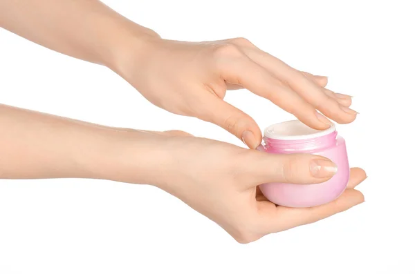 Thema Körperpflege und Gesundheit: die Hand einer Frau mit einem rosafarbenen Glas Creme auf weißem Hintergrund im Atelier — Stockfoto