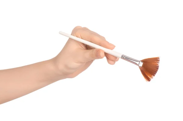 Makeup and beauty topic: a woman's hand holding a brush makeup isolated on white background in studio — Zdjęcie stockowe