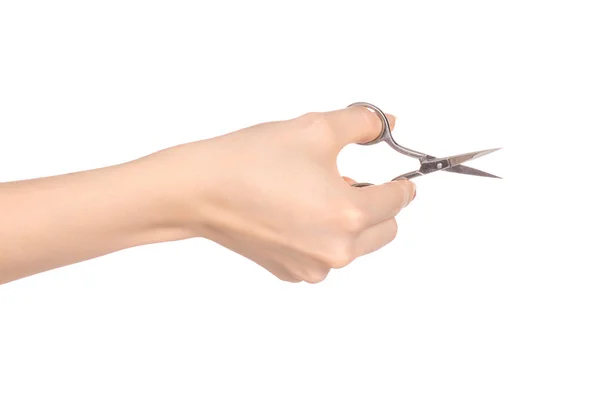 Здоров'я та догляд за собою: жіноча рука тримає ножиці для манікюру ізольовані на білому тлі в студії — стокове фото