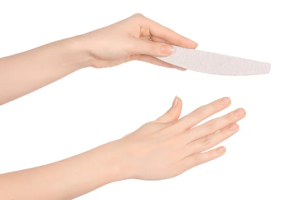 Health and hand care topic: a woman 's hand holding a nail file for manicure isolated on white background in studio — стоковое фото