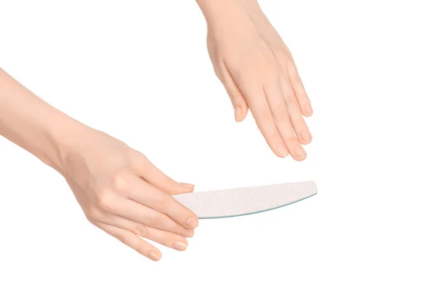 Tema de salud y cuidado de la mano: la mano de una mujer sosteniendo una lima de uñas para manicura aislada sobre fondo blanco en el estudio — Foto de Stock