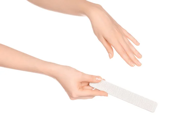 Topik kesehatan dan perawatan tangan: tangan seorang wanita memegang sebuah berkas kuku untuk manikur yang terisolasi di latar belakang putih di studio — Stok Foto