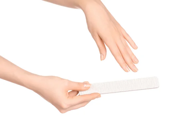 Tópico de saúde e cuidados com as mãos: a mão de uma mulher segurando um arquivo de unhas para manicure isolado em fundo branco no estúdio — Fotografia de Stock