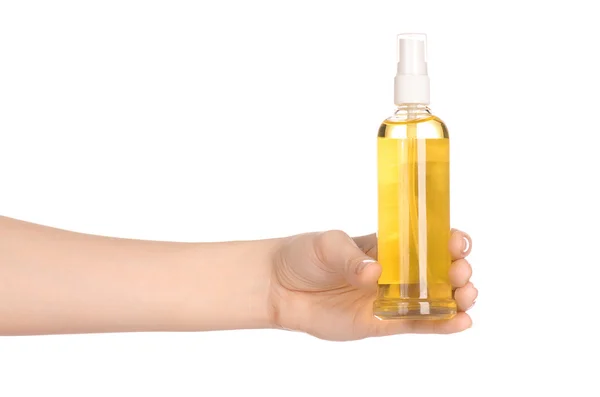 Masaje y cuidado corporal: la mano de una mujer sosteniendo una botella de aceite al spa aislado sobre fondo blanco en el estudio —  Fotos de Stock