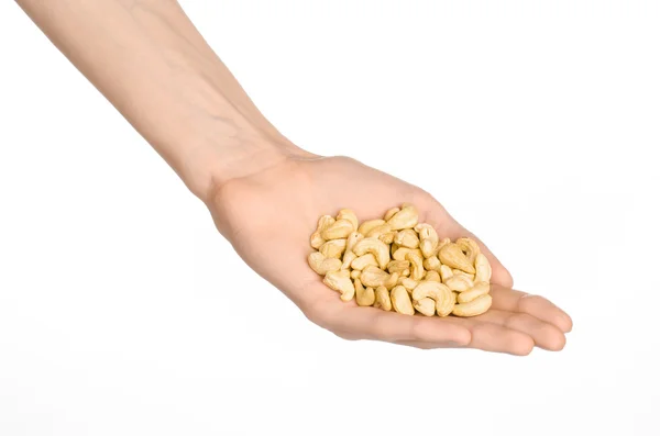 Nuts and cooking theme: man's hand holding a cashew nuts isolated on white background in studio — Stock Photo, Image
