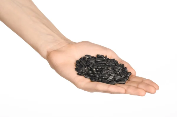 Nuts and meal preparation topic: human hand holding roasted sunflower seeds on a white isolated background in studio — Stockfoto