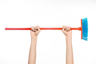 Ev konu temizlik: Studio beyaz bir arka plan üzerinde izole kırmızı bir süpürge tutan eller