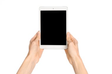 Presentation and advertising touchscreen topic: human hand holding a white tablet touch computer gadget with touch blank black screen isolated on a white background in the studio, first-person view