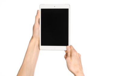 Presentation and advertising touchscreen topic: human hand holding a white tablet touch computer gadget with touch blank black screen isolated on a white background in the studio, first-person view