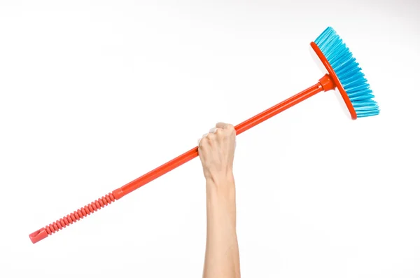 Limpeza do tema da casa: mão humana segurando uma vassoura vermelha isolada em um fundo branco no estúdio — Fotografia de Stock