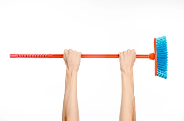 Cleaning the house topic: human hand holding a red broom isolated on a white background in studio — Stock Photo, Image