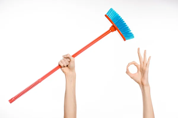 Cleaning the house topic: human hand holding a red broom isolated on a white background in studio — Stock Photo, Image