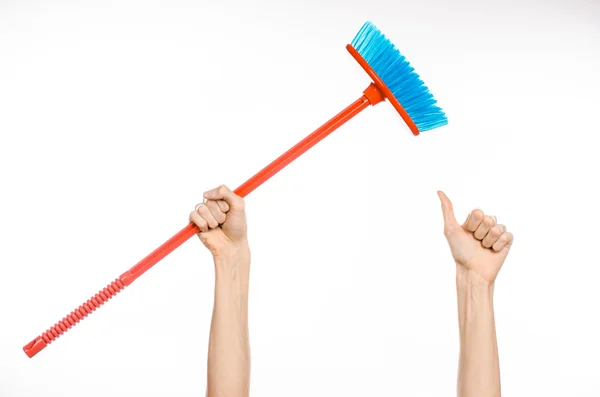 Cleaning the house topic: human hand holding a red broom isolated on a white background in studio — Stock Photo, Image