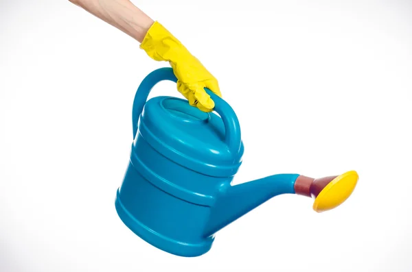 Caring for the plants and the garden theme: the human hand in yellow rubber gloves holding a large blue plastic watering can isolated on white background in studio — Stock Photo, Image