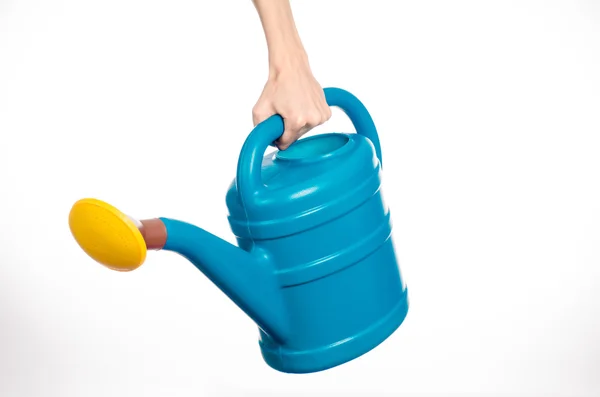 Caring for the plants and the garden theme: man's hand holding a large blue plastic watering can isolated on white background in studio — Stock Photo, Image