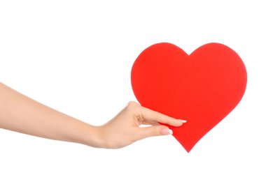 Love and greetings card theme: beautiful female hand holding a paper card red heart isolated on a white background in studio