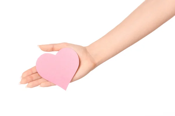 Tema de la tarjeta de amor y saludos: hermosa mano femenina sosteniendo una tarjeta de papel corazón rosa aislado sobre fondo blanco en el estudio —  Fotos de Stock