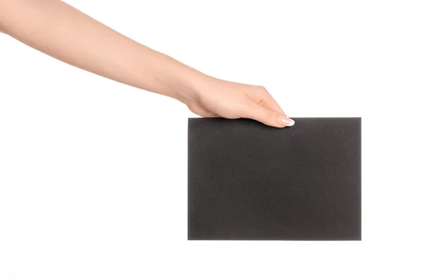 Branding et thème publicitaire : belle main féminine tenant vide carte de papier noir isolé sur fond blanc — Photo