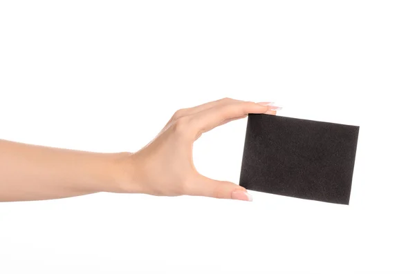 Tema de marca y publicidad: hermosa mano femenina sosteniendo la tarjeta de papel negro vacía aislada sobre fondo blanco — Foto de Stock