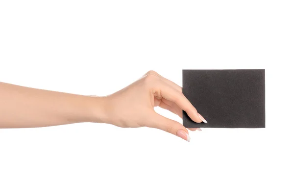 Тема брендингу та реклами: красива жіноча рука тримає порожню чорну паперову картку ізольовано на білому тлі — стокове фото