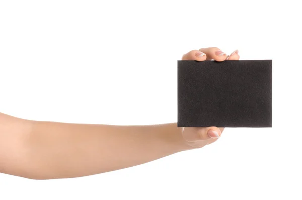 Tema de marca y publicidad: hermosa mano femenina sosteniendo la tarjeta de papel negro vacía aislada sobre fondo blanco — Foto de Stock