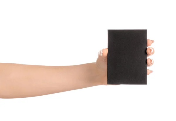 Tema de marca y publicidad: hermosa mano femenina sosteniendo la tarjeta de papel negro vacía aislada sobre fondo blanco — Foto de Stock