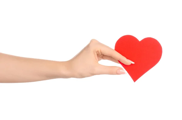 Amor e cumprimentos tema do cartão: bela mão feminina segurando um cartão de papel coração vermelho isolado em um fundo branco no estúdio — Fotografia de Stock