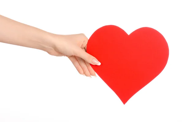 Tema de la tarjeta de amor y saludos: hermosa mano femenina sosteniendo una tarjeta de papel corazón rojo aislado sobre un fondo blanco en el estudio — Foto de Stock