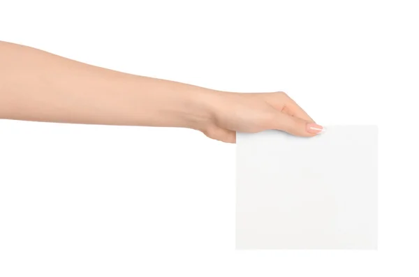 Marca y publicidad tema: hermosa mano femenina sosteniendo una tarjeta de papel blanco en blanco aislado sobre fondo blanco — Foto de Stock