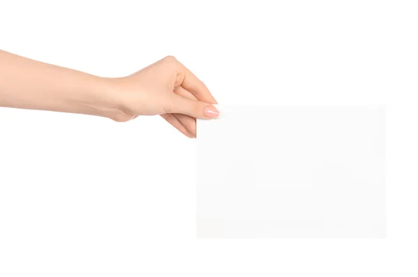 Marca y publicidad tema: hermosa mano femenina sosteniendo una tarjeta de papel blanco en blanco aislado sobre fondo blanco — Foto de Stock