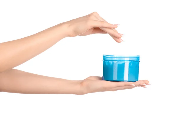 Health and body care topic: a woman's hand holding a blue jar with cream isolated on white background — Stock Photo, Image