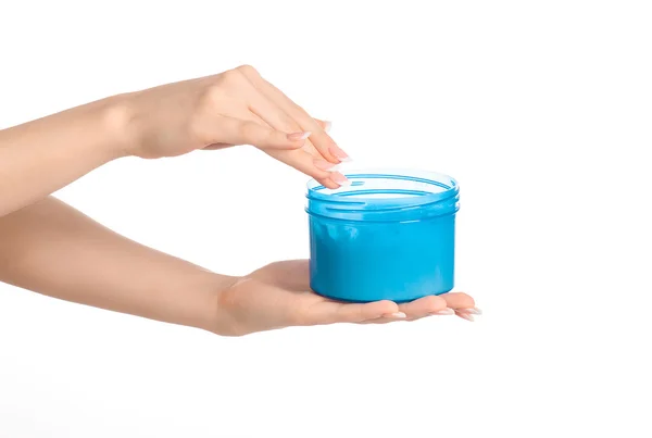Health and body care topic: a woman's hand holding a blue jar with cream isolated on white background — 스톡 사진