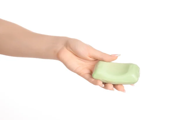 Tópico de higiene e cuidados de saúde: a mão de uma mulher segurando uma barra verde de sabão isolado em fundo branco no estúdio — Fotografia de Stock