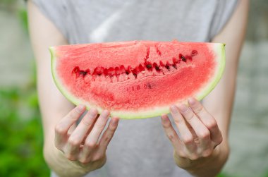 Yaz ve taze karpuz Tema: bir adam bir dilim karpuz yeşil bir arka plan üzerinde tutar.