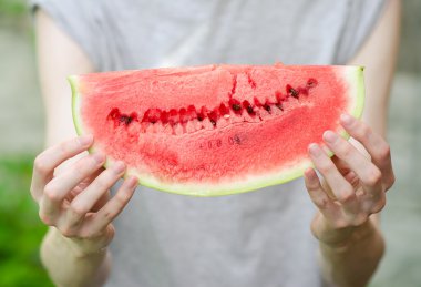 Yaz ve taze karpuz Tema: bir adam bir dilim karpuz yeşil bir arka plan üzerinde tutar.