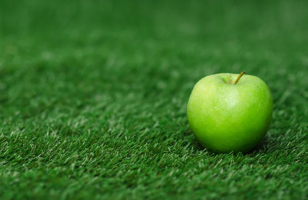 Thème alimentation végétale saine : pomme verte mûre couchée sur l'herbe verte — Photo