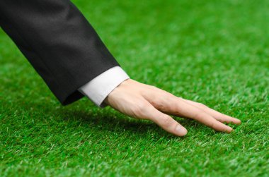 Doğa ve iş Konu: yeşil çim siyah elbiseli adam el gösterir