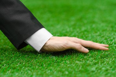 Doğa ve iş Konu: yeşil çim siyah elbiseli adam el gösterir
