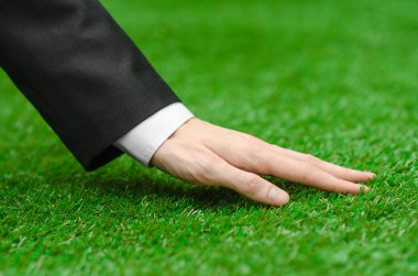 Doğa ve iş Konu: yeşil çim siyah elbiseli adam el gösterir