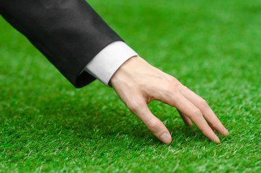 Doğa ve iş Konu: yeşil çim siyah elbiseli adam el gösterir